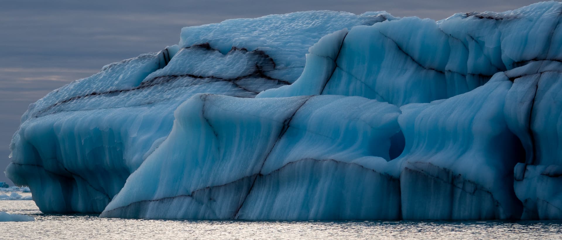 Blue glacial iceberg drifting in cold open water